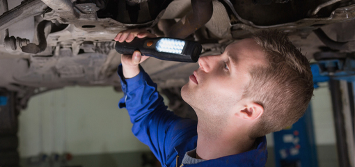 MOT inspector checking underside of vehicle