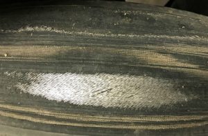 A close up photo of a tyre worn through to the cords.