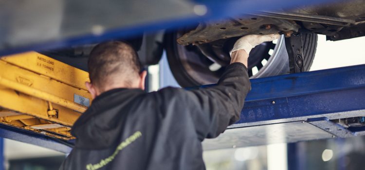 MOT tester inspecting under car