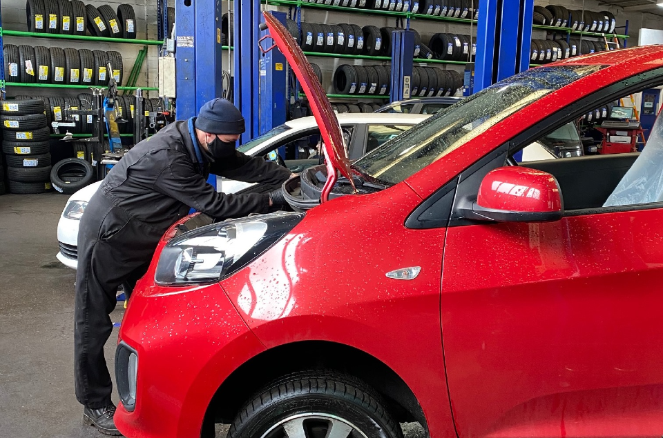 MOT tester inspecting under car