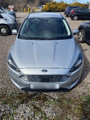 Photo of a car in a gravel car park during an MOT test